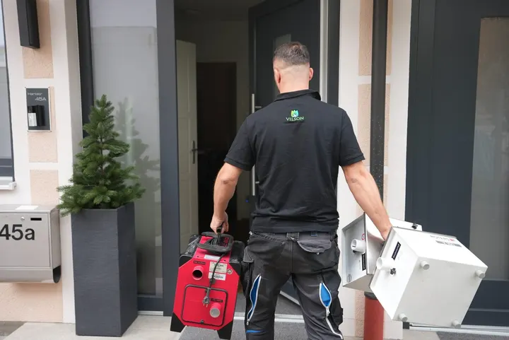 Vilson-Techniker trägt Bautrockner in ein Haus